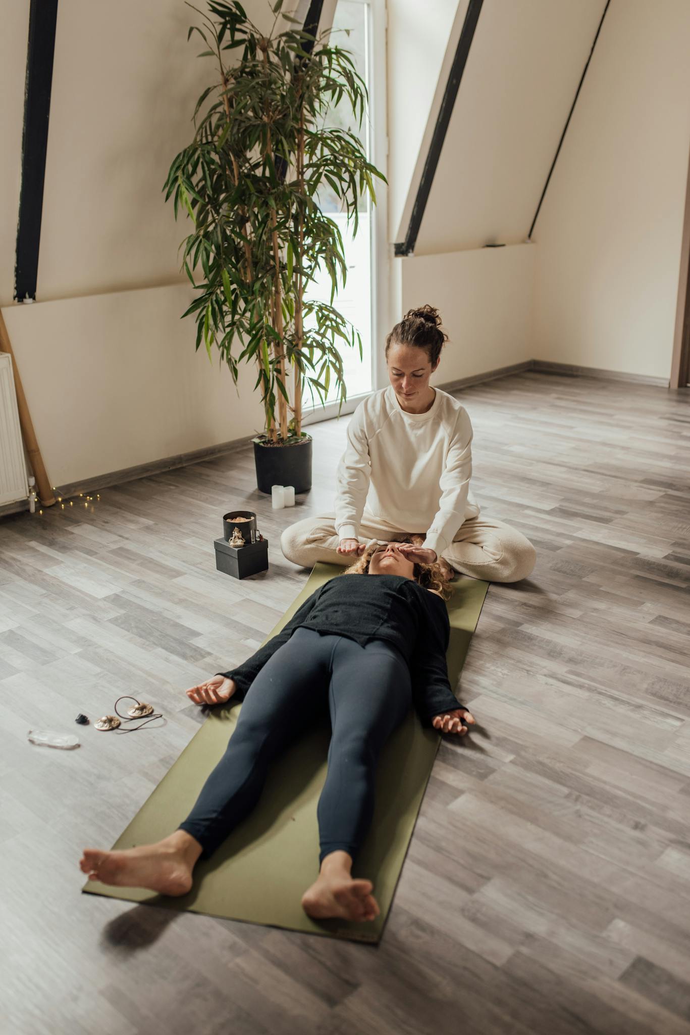 1st page - offer Programează o sesiune de breathwork 1:1 A soothing therapy session indoors with a person relaxing on a yoga mat, guided by a therapist.